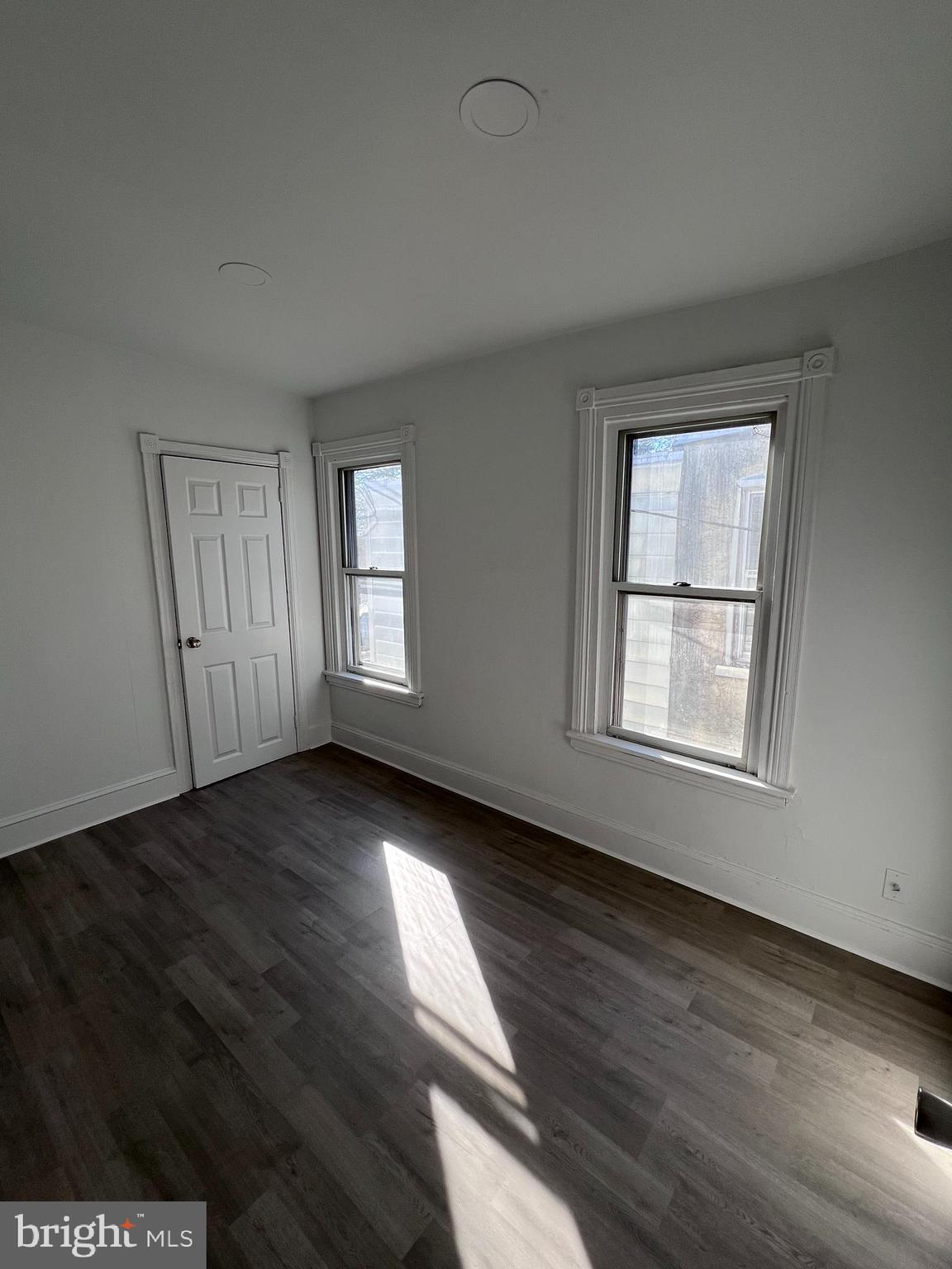 2117 West 4th Street Chester, PA 19013 - Photo 19 of 35 an empty room with wooden floor and windows