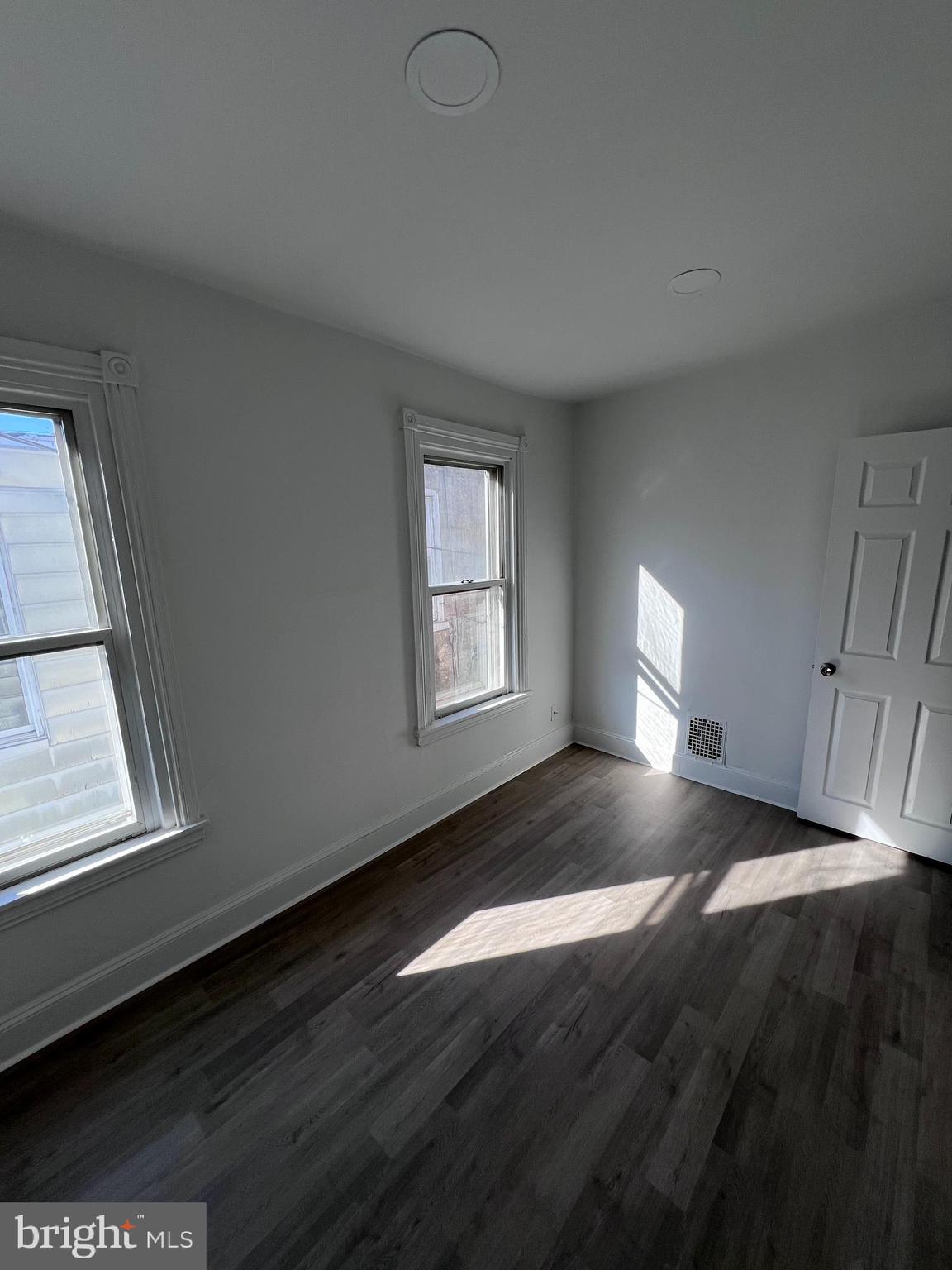 2117 West 4th Street Chester, PA 19013 - Photo 20 of 35 a view of an empty room with wooden floor and a window