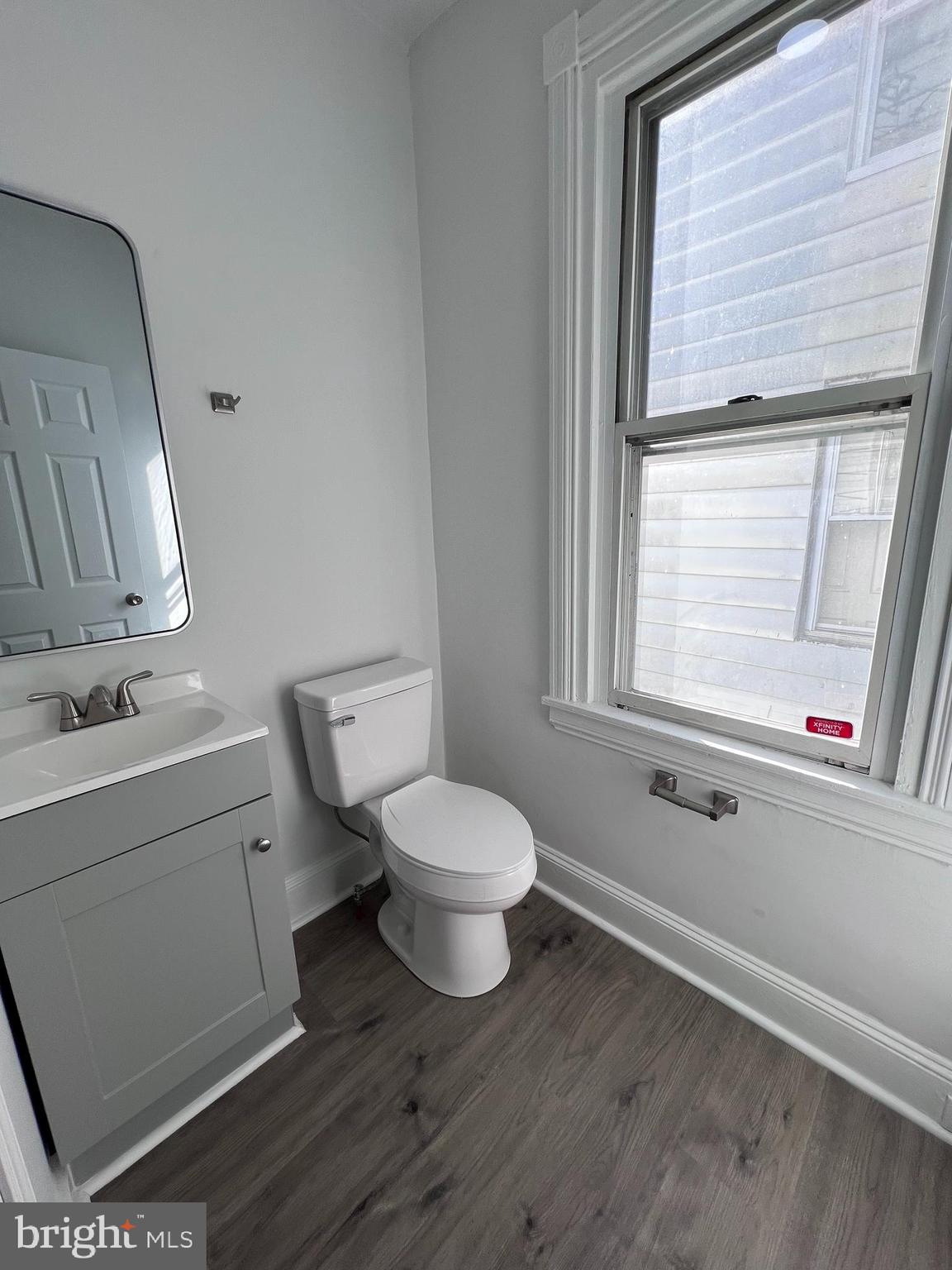 2117 West 4th Street Chester, PA 19013 - Photo 8 of 35 a bathroom with a toilet a sink a mirror and a window