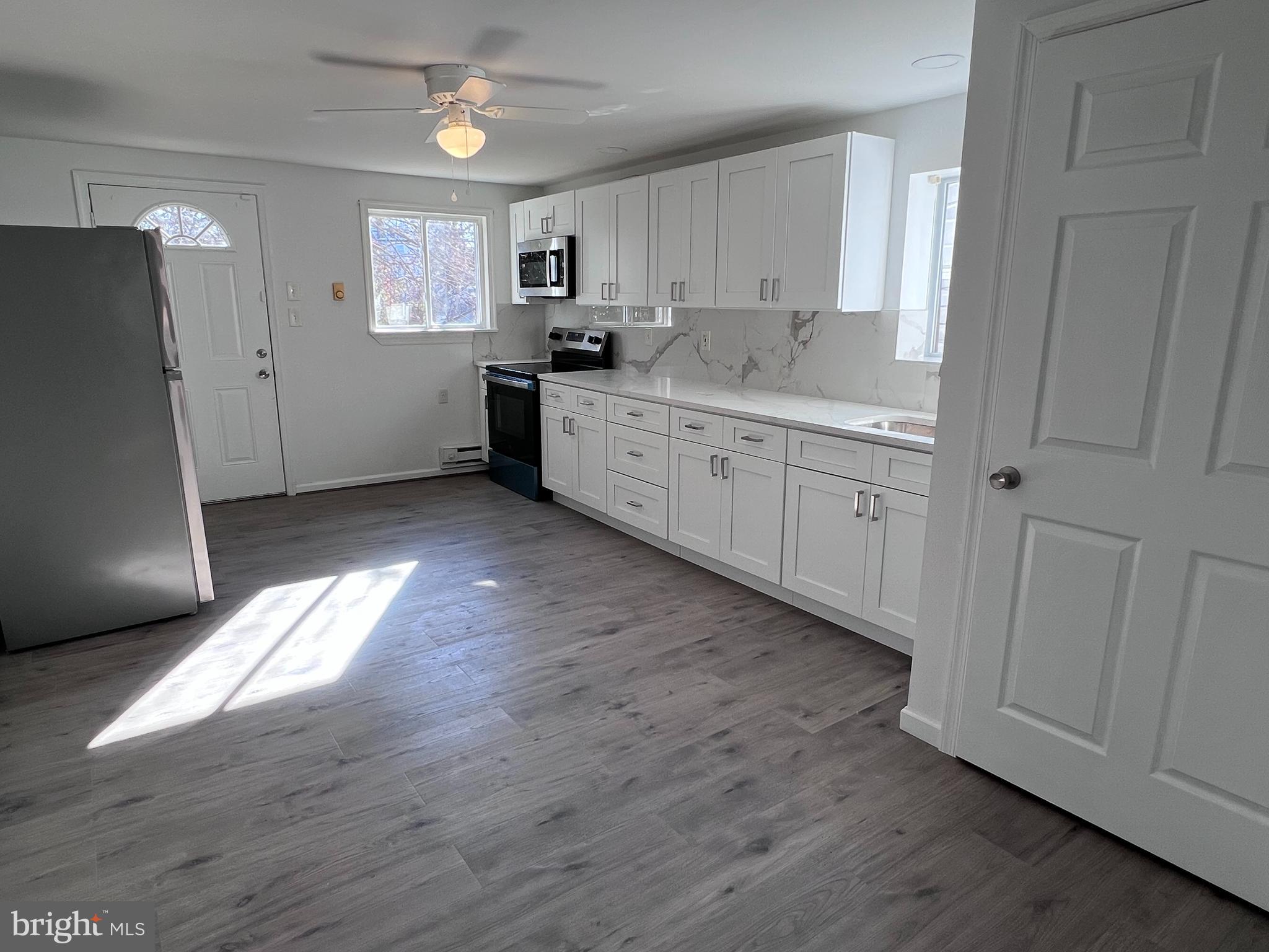 2117 West 4th Street Chester, PA 19013 - Photo 9 of 35 a kitchen with stainless steel appliances granite countertop a sink cabinets and wooden floor
