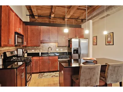 a kitchen with stainless steel appliances granite countertop a refrigerator and a stove top oven