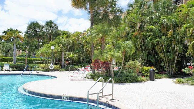a view of a white house with a yard and plants