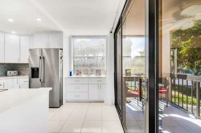 a kitchen with a refrigerator a stove top oven and a large window