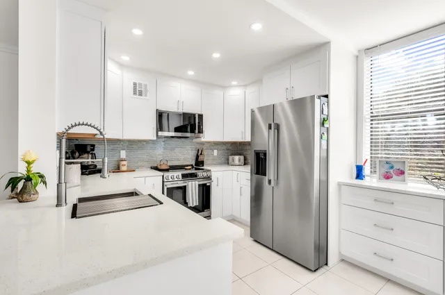 a kitchen with stainless steel appliances a refrigerator stove microwave and sink