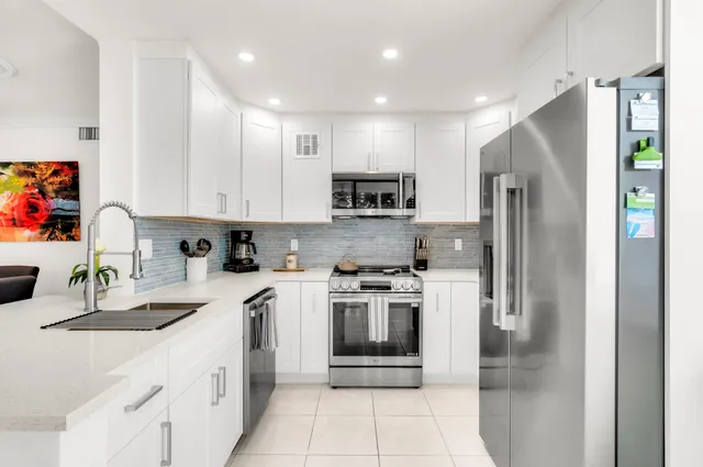 a kitchen with stainless steel appliances granite countertop a refrigerator sink and stove