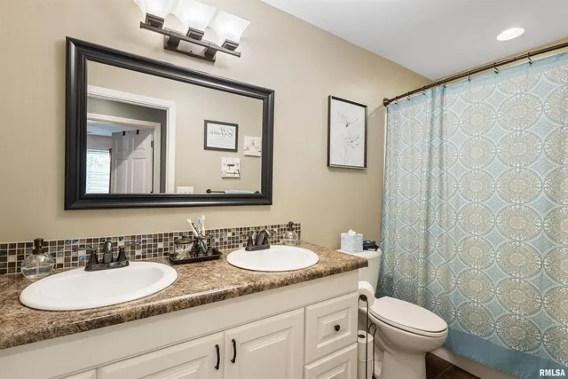 a bathroom with a granite countertop sink a toilet and a mirror
