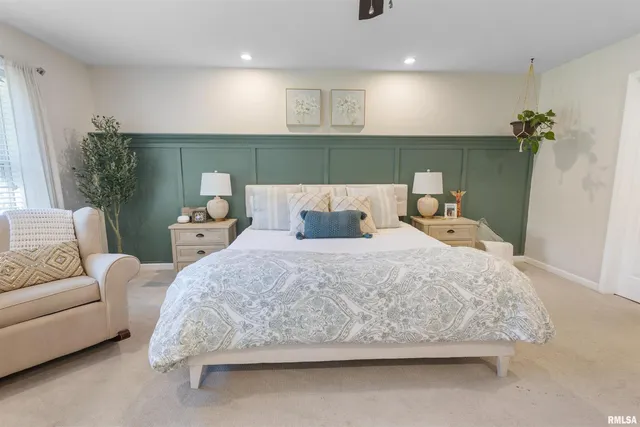 a bedroom with a bed a couch and a potted plant