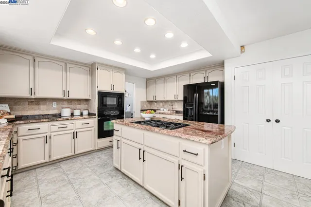 a kitchen with a stove cabinets and chairs