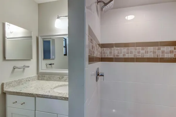 a bathroom with a granite countertop sink a toilet and mirror