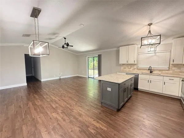 a large kitchen with a large counter top appliances and cabinets