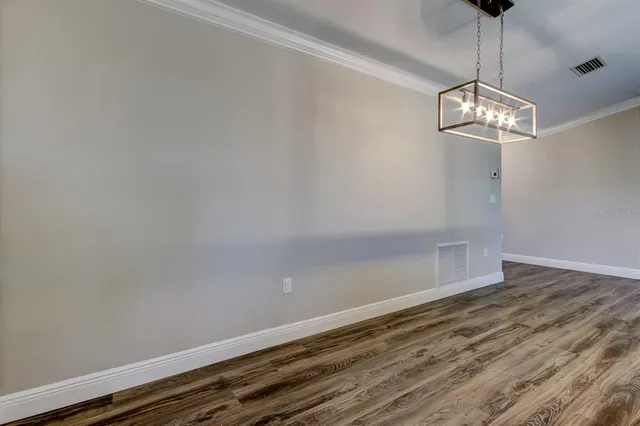 a view of a room with wooden floor and chandelier