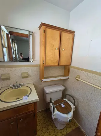 a bathroom with a toilet a sink and mirror