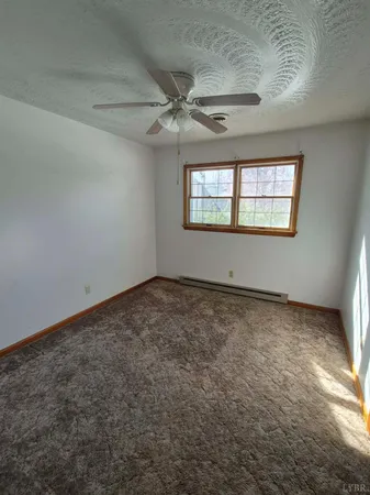 an empty room with a ceiling fan and window