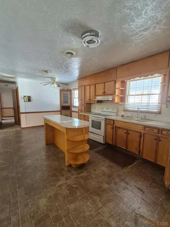 a large kitchen with a stove a sink dishwasher and a refrigerator