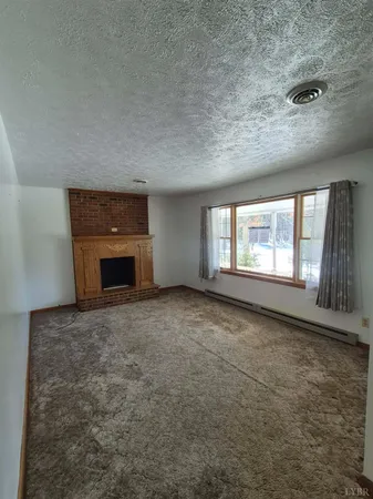 an empty room with fireplace and a window