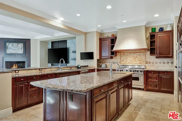 a kitchen with stainless steel appliances granite countertop a kitchen island a stove and a sink