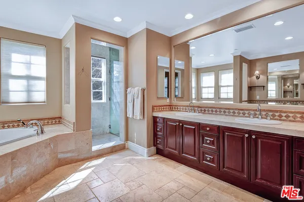 a spacious bathroom with a tub sink shower and mirror