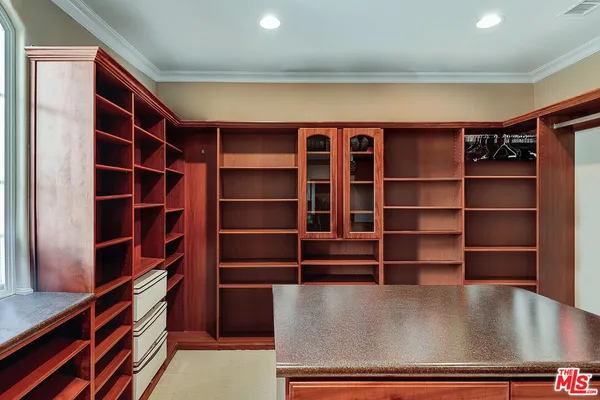 a view of walk in closet with empty racks