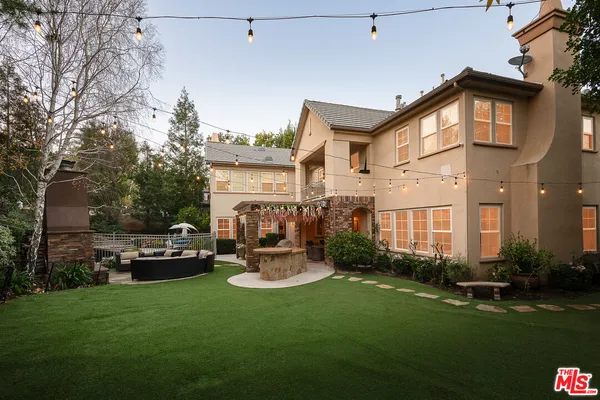 a view of a house with backyard and sitting area