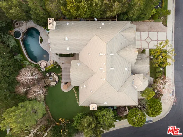 an aerial view of a house with swimming pool and a yard