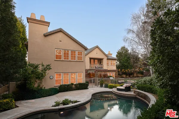 a view of swimming pool with lawn chairs and plants