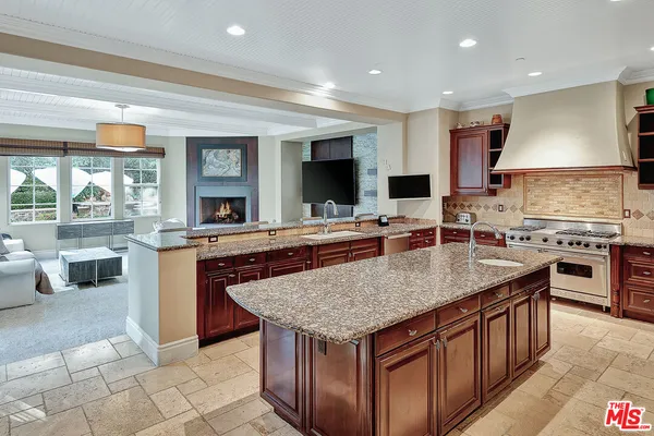 a kitchen with stainless steel appliances granite countertop a stove a sink and a refrigerator