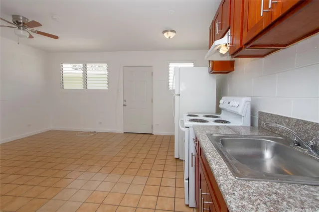 a kitchen with a sink a stove top oven and cabinetry