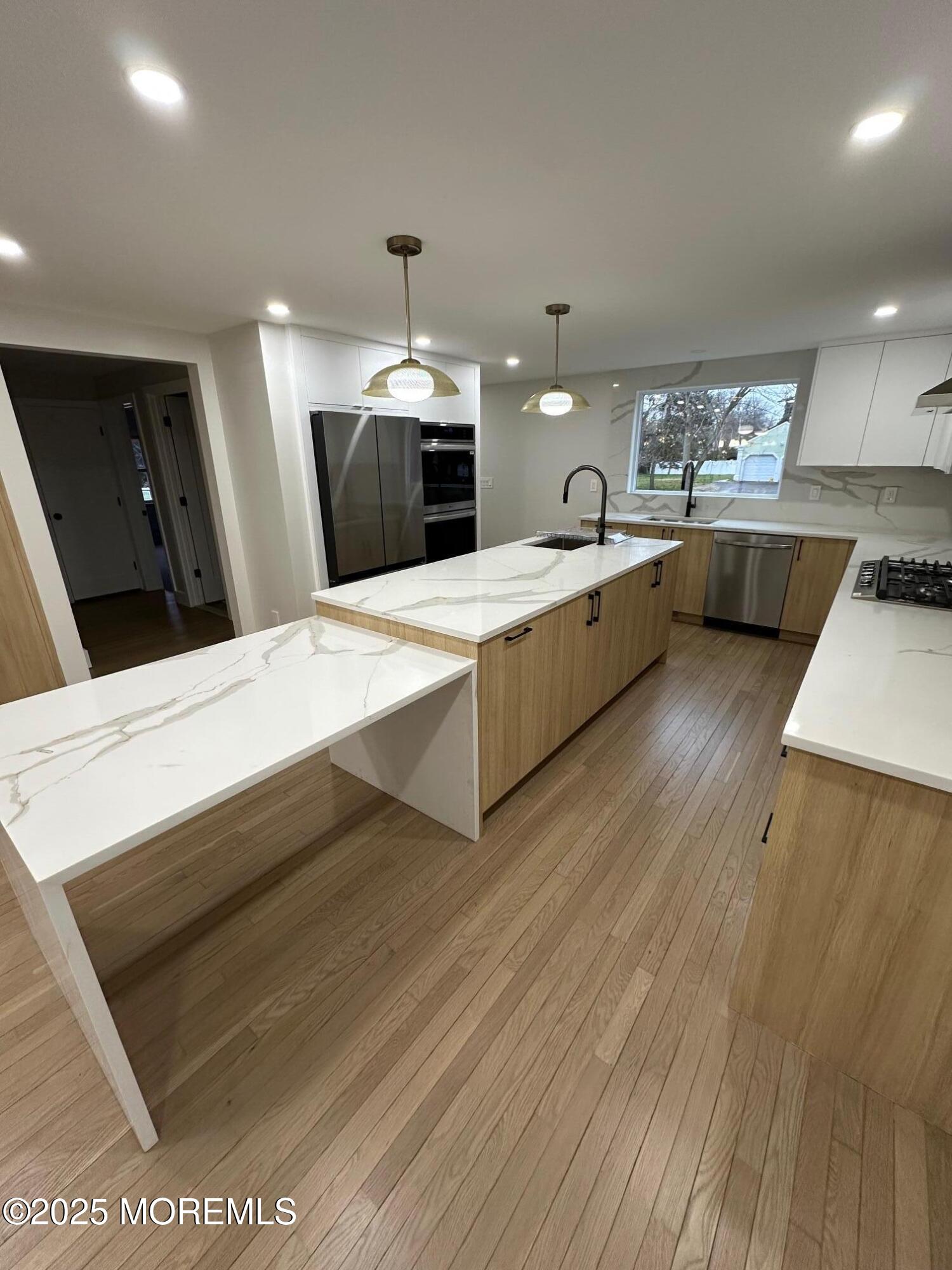 469 Wall Street Eatontown, NJ 07724 - Photo 4 of 17 a large white kitchen with sink a refrigerator and a stove