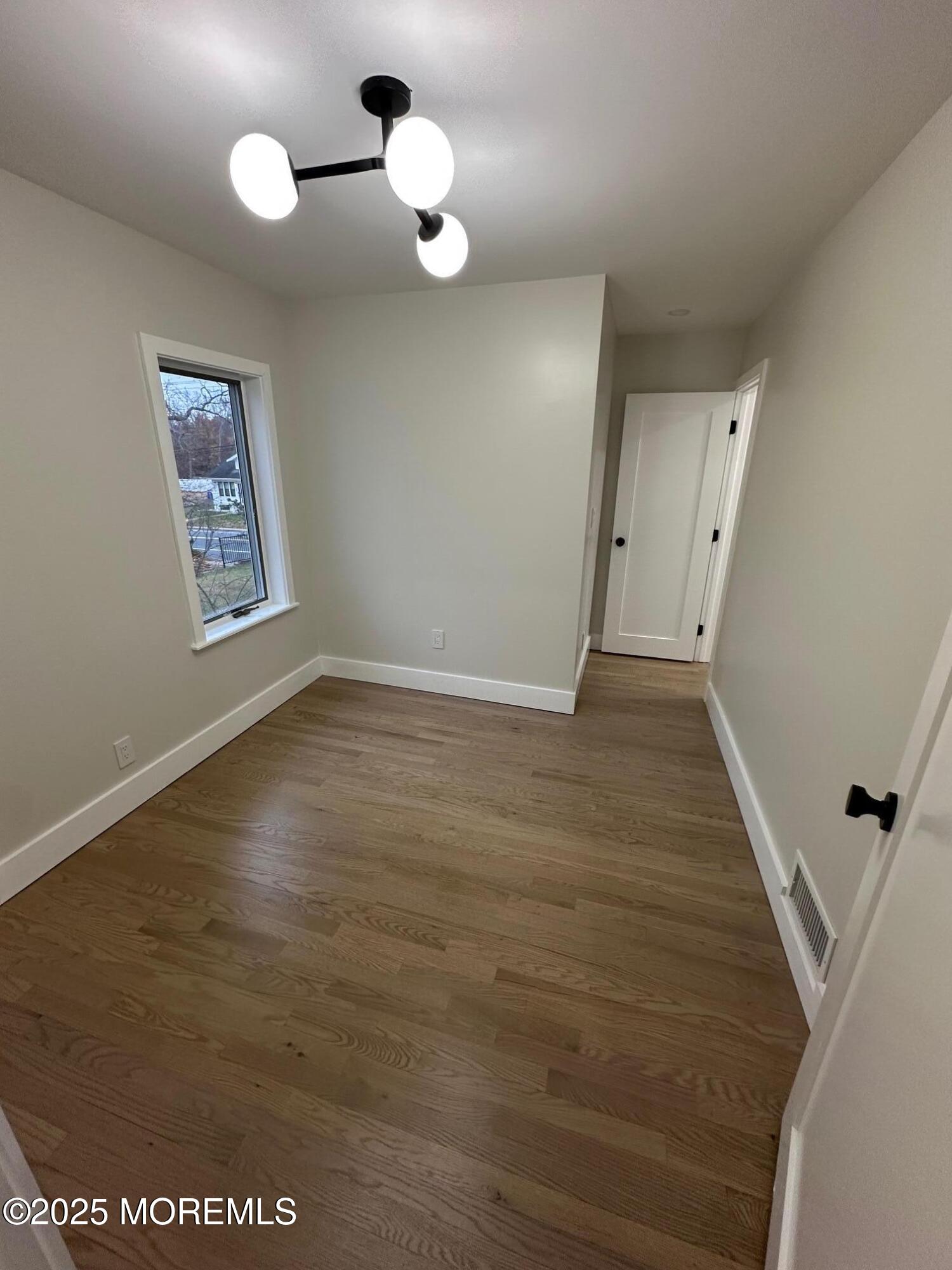 469 Wall Street Eatontown, NJ 07724 - Photo 9 of 17 wooden floor in an empty room with a window