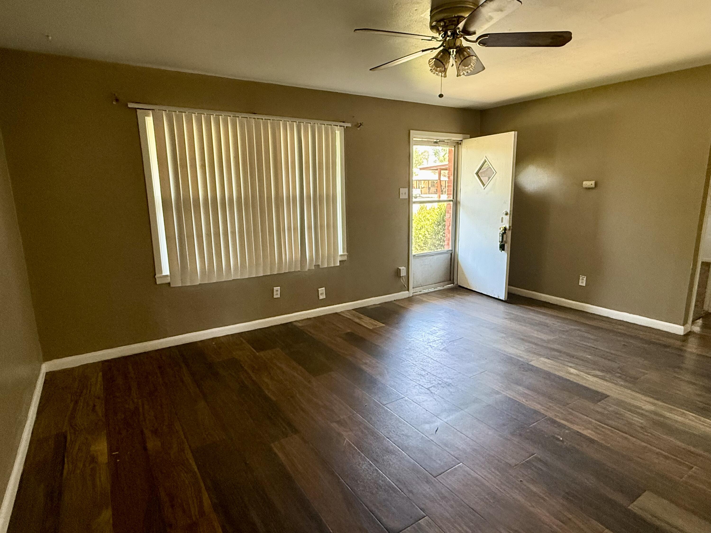 2817 63rd Street Lubbock, TX 79413 - Photo 14 of 16 a view of an empty room with a window and wooden floor