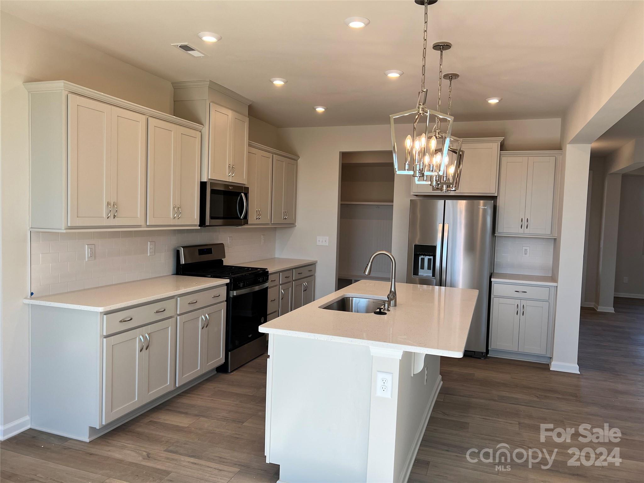 2541 Crimson Way Monroe, NC 28112 - Photo 2 of 22 a kitchen with kitchen island stainless steel appliances a stove refrigerator sink and microwave
