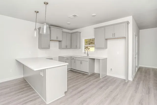 a kitchen with a sink a stove a refrigerator and white cabinets