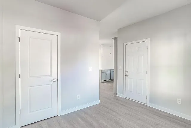 an empty room with wooden floor & closet area