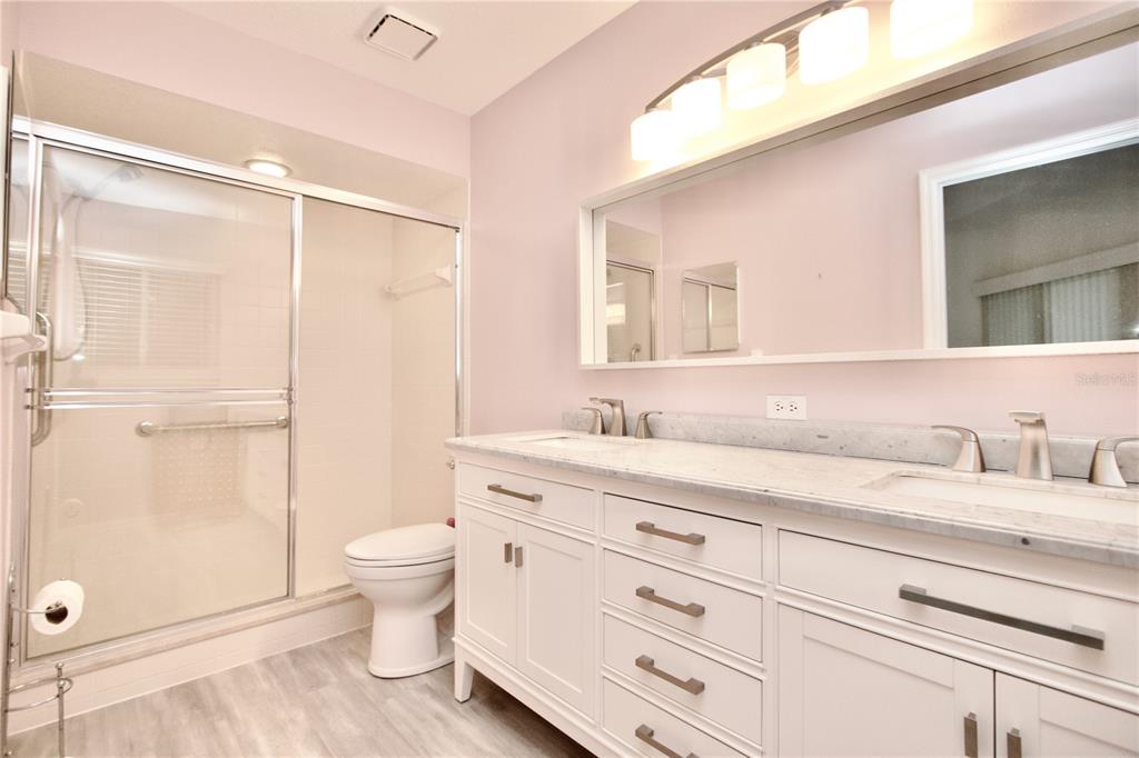 7842 Tenby Court New Port Richey, FL 34655 - Photo 5 of 27 a bathroom with a granite countertop sink a toilet and a shower
