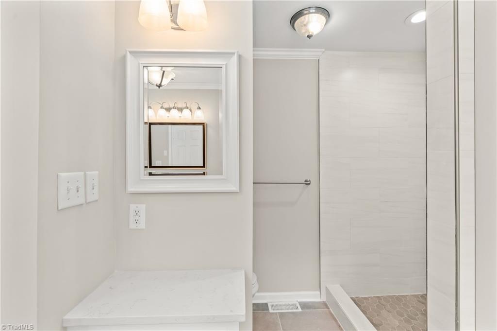 5902 Siler Road Greensboro, NC 27406 - Photo 21 of 49 Primary bathroom with additional counter and cabinet. Sliding glass shower door will be installed soon.