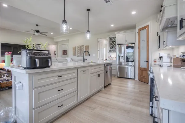 a kitchen with stainless steel appliances kitchen island granite countertop a refrigerator and a stove top oven