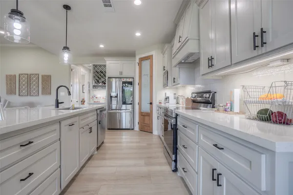 a large kitchen with stainless steel appliances lots of counter space and a sink
