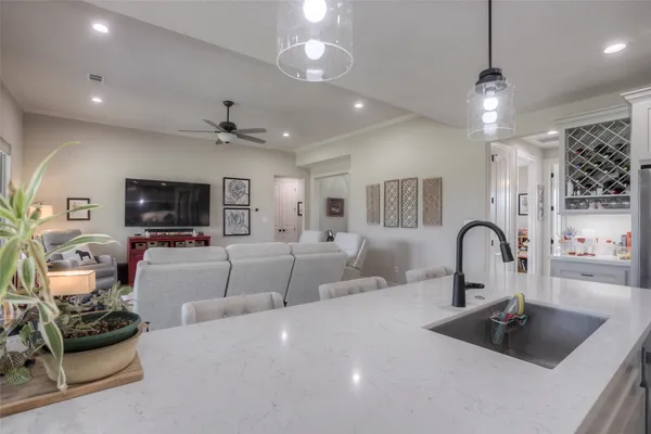 a kitchen with a faucet a chandelier and living room view