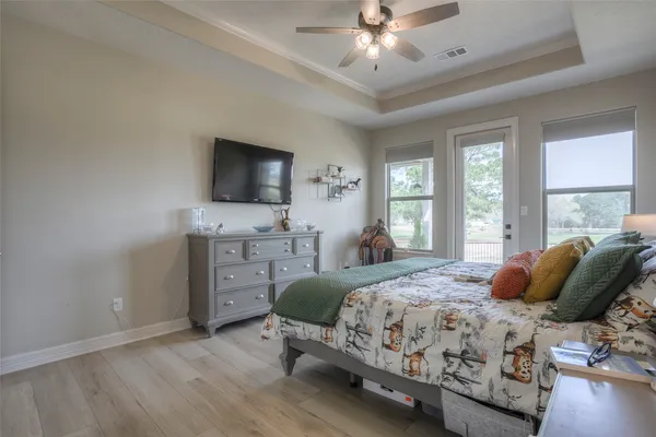a bedroom with a bed and a flat tv screen on dresser
