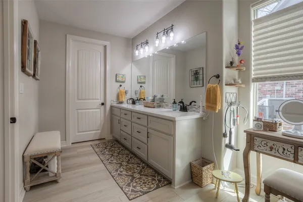 a bathroom with a double vanity sink a toilet and shower