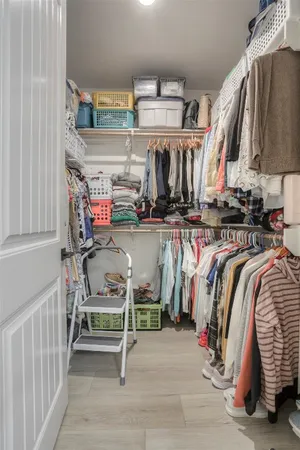 a view of walk in closet with clothes and shoes