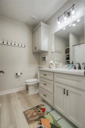 a bathroom with a granite countertop sink a toilet and a mirror