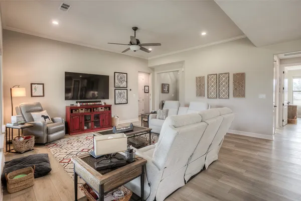 a living room with furniture a flat screen tv and kitchen view