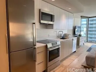 a kitchen with stainless steel appliances granite countertop a refrigerator a stove a sink and a microwave