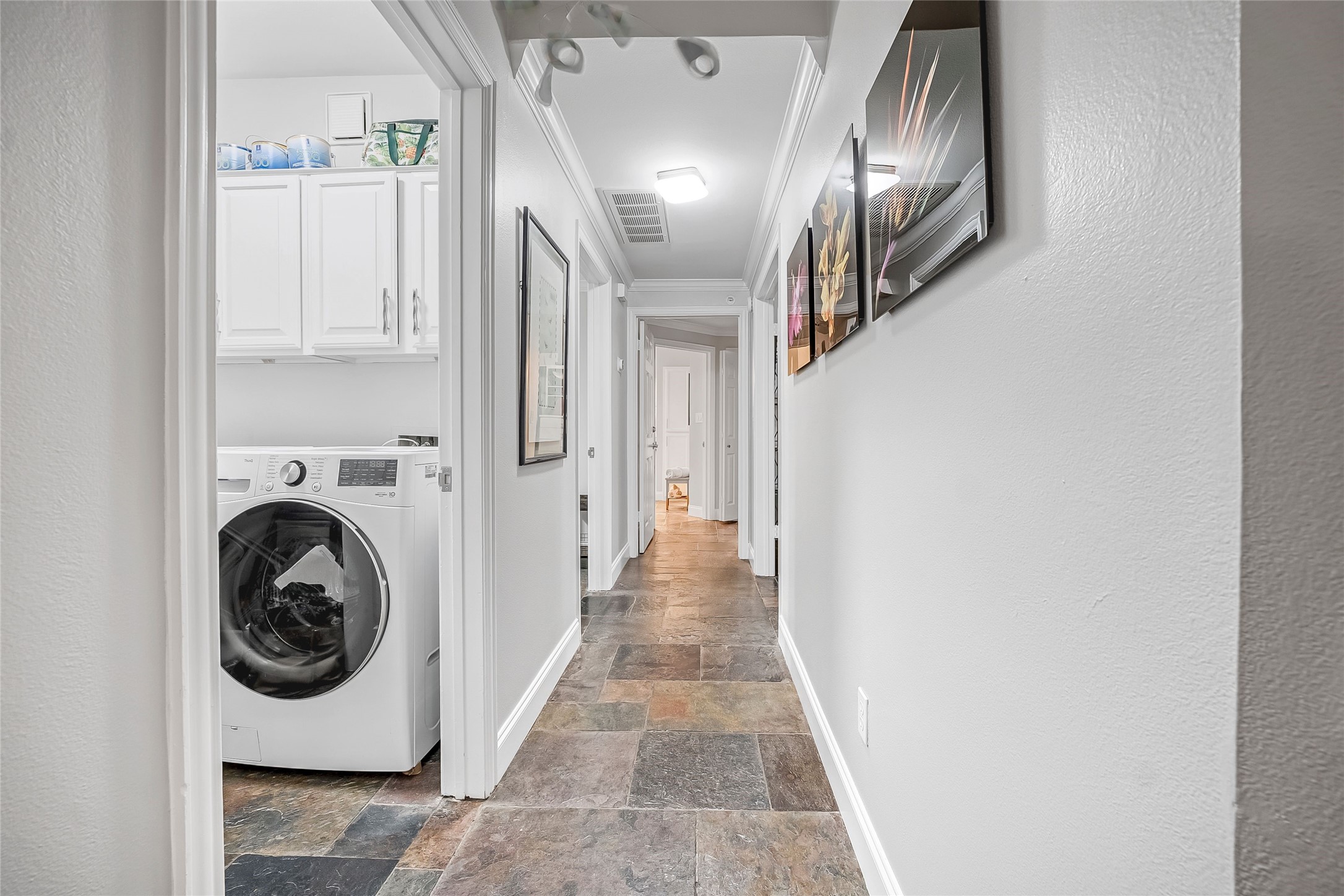 2111 Welch Street, Unit A113 Houston, TX 77019 - Photo 21 of 30 Sleek slate flooring throughout the hall, 2nd bedroom, and wet areas. No carpet. Clean lines. Effortless upkeep! This hall leads to the bedrooms.
