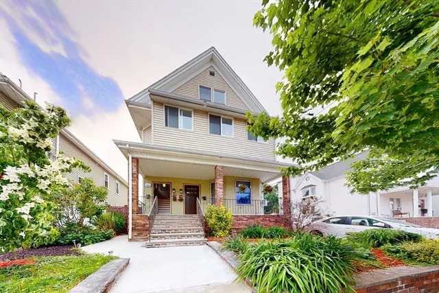 a front view of a house with a yard and potted plants