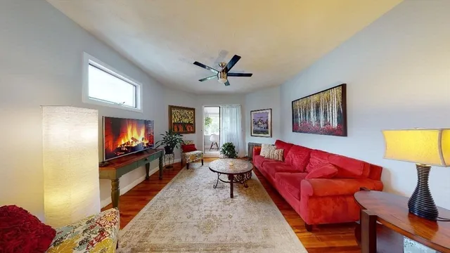 a living room with furniture a flat screen tv and a window
