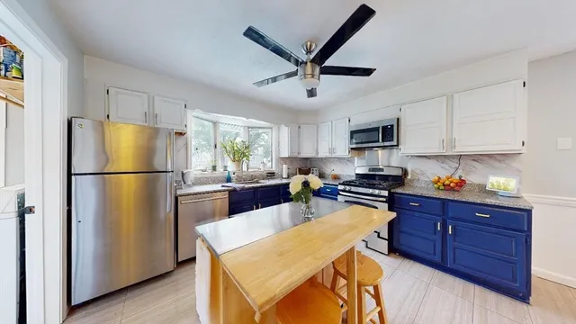 a kitchen with stainless steel appliances granite countertop a refrigerator a stove a sink a center island and cabinets