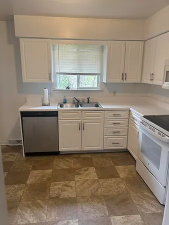 a bathroom with a granite countertop sink and a toilet