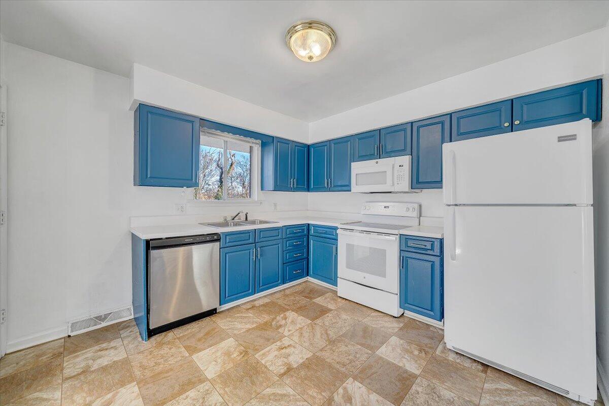 725 Ramada Road Vinton, VA 24179 - Photo 16 of 38 a kitchen with granite countertop a refrigerator a stove a sink dishwasher and a refrigerator with wooden cabinets
